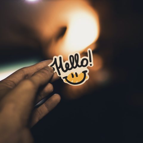 person holding Hello! sticker