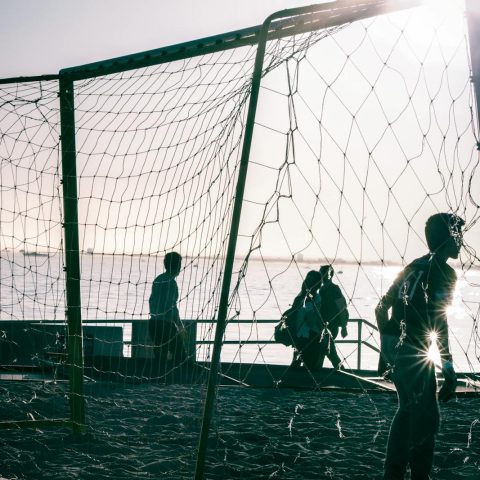 Man Standing on a Golf Goal Near the Body of Water