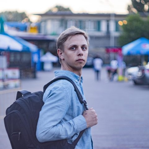 Man met rugzak op een zomerse bestemming als solo reiziger
