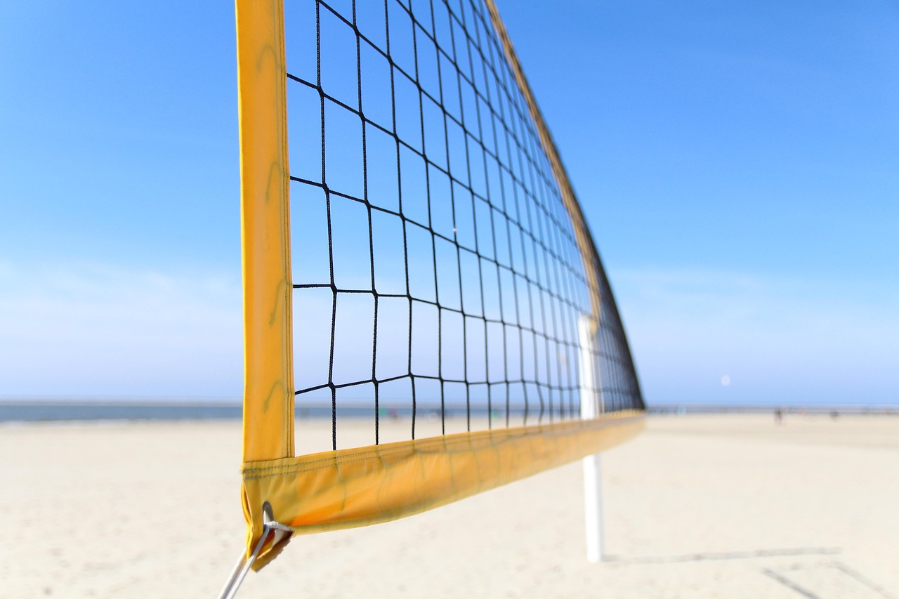 Mannen spelen beachvolleybal op een zonnig stadsstrand