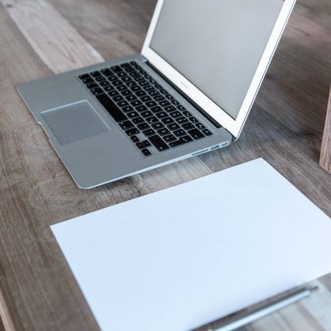 MacBook, iPhone en AirPods naast elkaar op een bureau