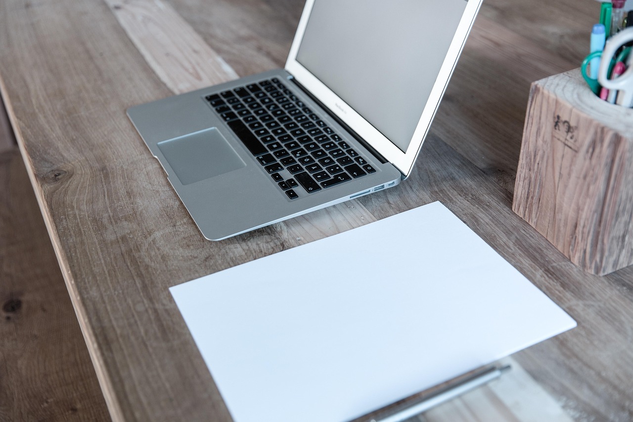 MacBook, iPhone en AirPods naast elkaar op een bureau
