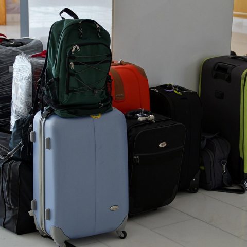 Man die zijn koffer inpakt voor een last-minute zomervakantie
