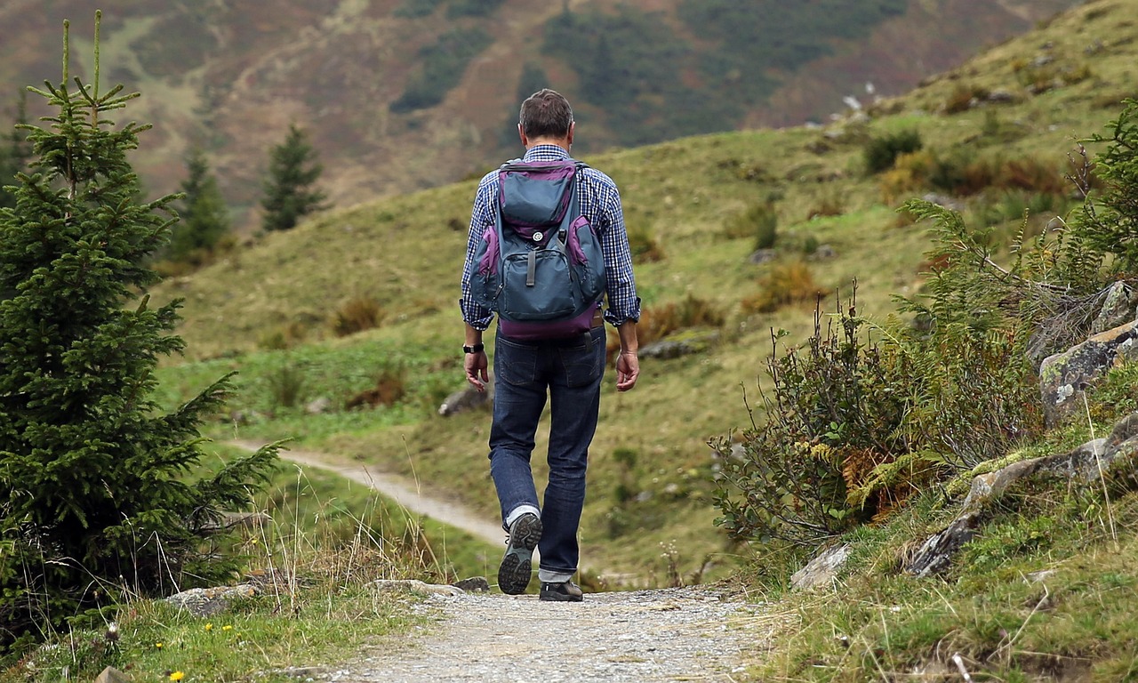Man op een bergpad tijdens een avontuurlijke eco-reis in de natuur