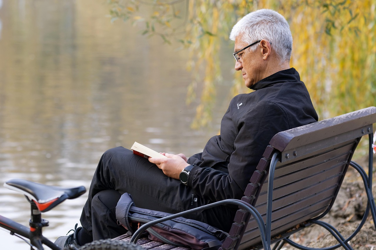 Man die een boek leest buiten in de zomer