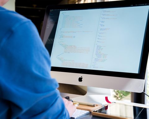 Man met koptelefoon geconcentreerd aan het werk achter zijn bureau
