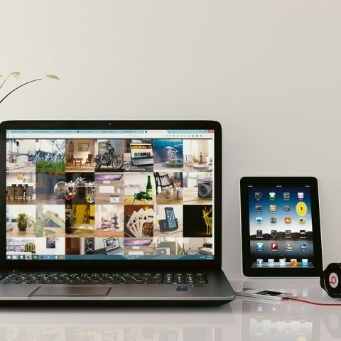 Een gaming-koptelefoon op een bureau naast een laptop, klaar voor zowel gamen als werken