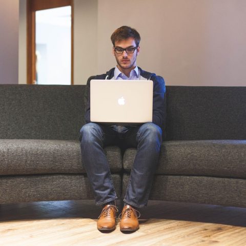 Jonge man die zijn financiën bekijkt op een laptop
