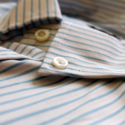 Twee mannen vergelijken overhemden in een kledingwinkel