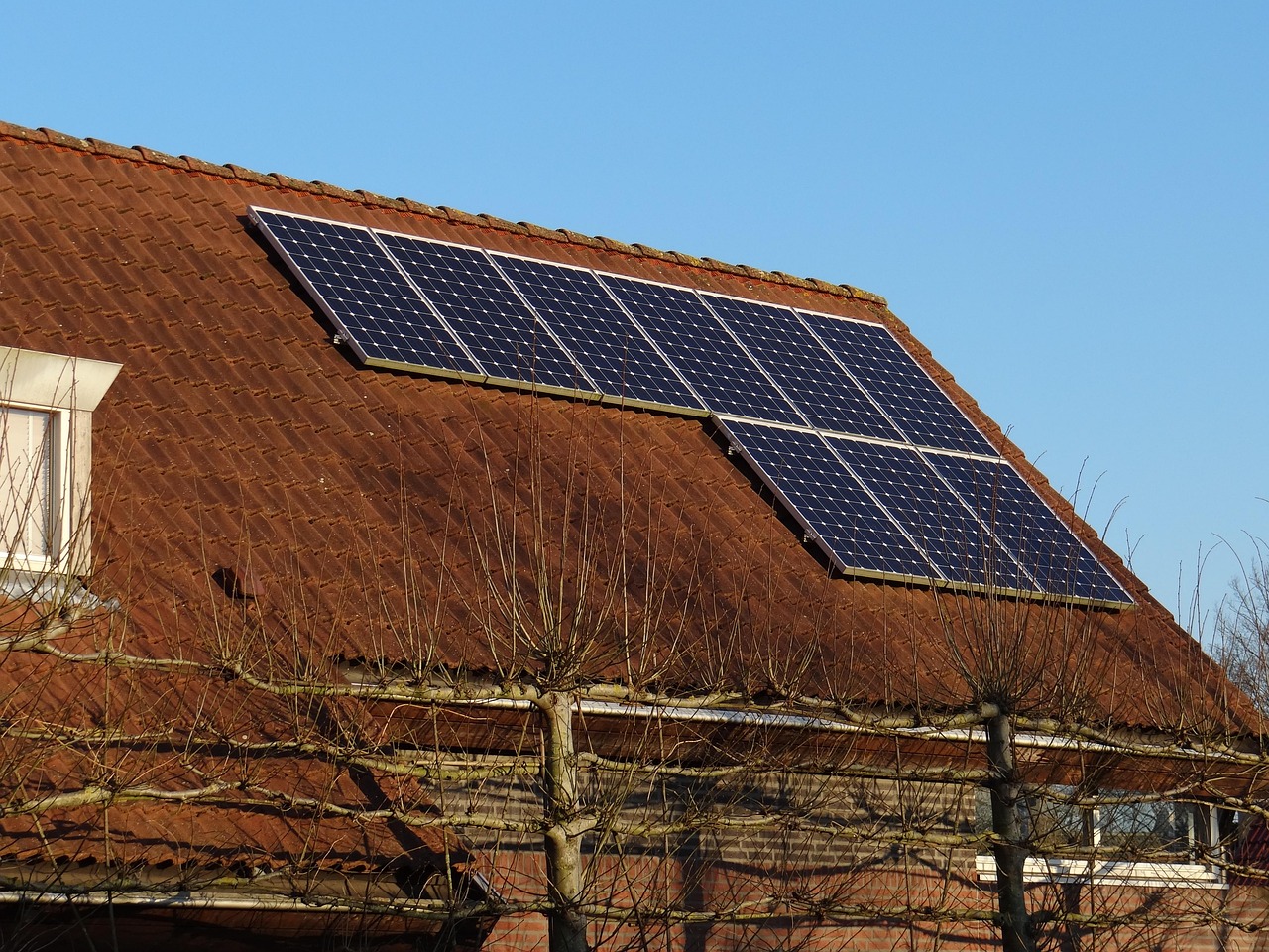 Zonnepanelen op een woning in de herfst met lage zonstand