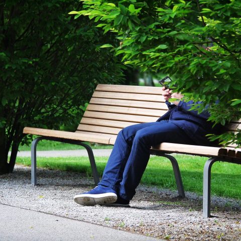 Man die zijn bankafschrift bekijkt op zijn telefoon om abonnementen te controleren