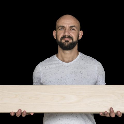 Een man werkt geconcentreerd in een houten werkplaats na zijn carrièreswitch